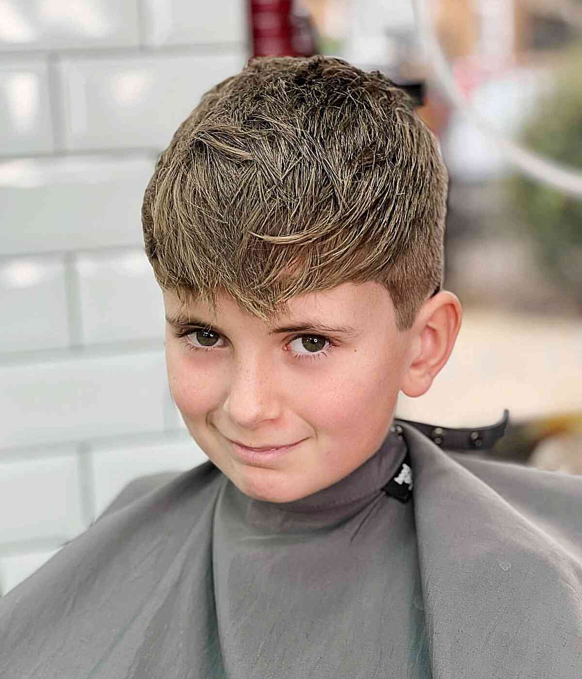 Cabelo penteado para a frente com um leve desbotamento para meninos com cabelo de comprimento médio na parte superior