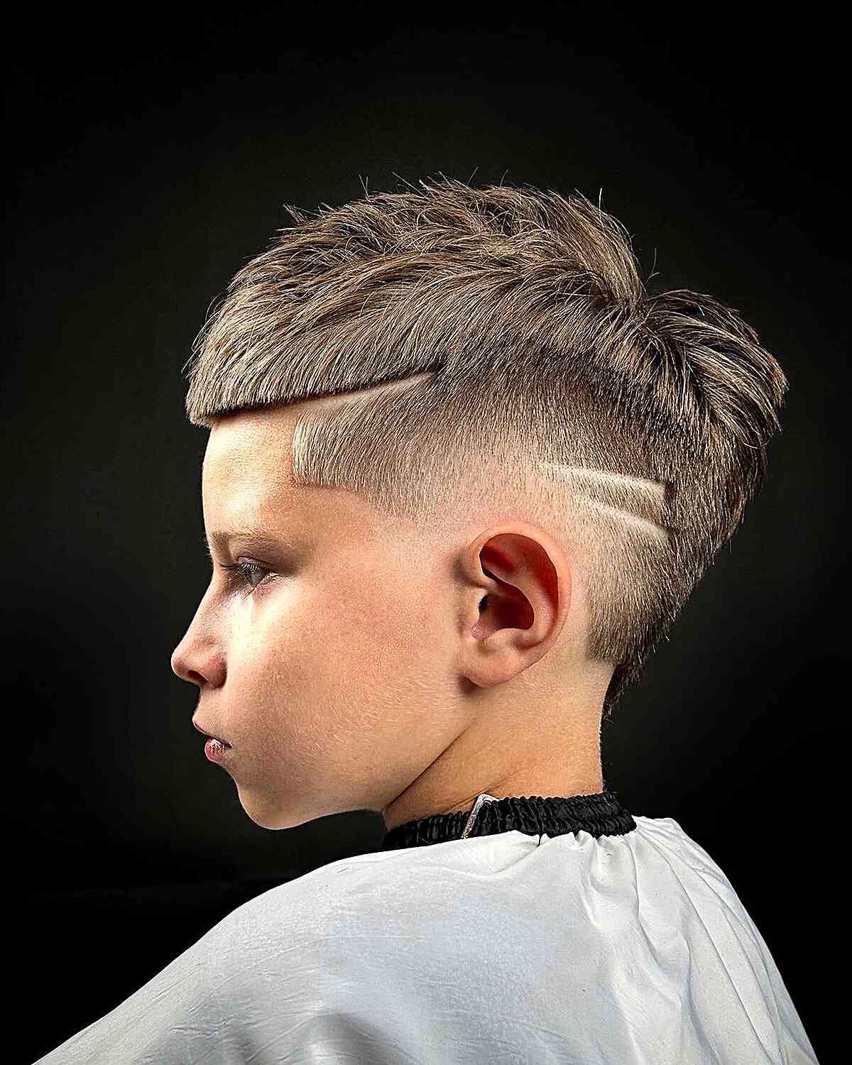 Padrões raspados legais em um corte de cabelo curto para meninos
