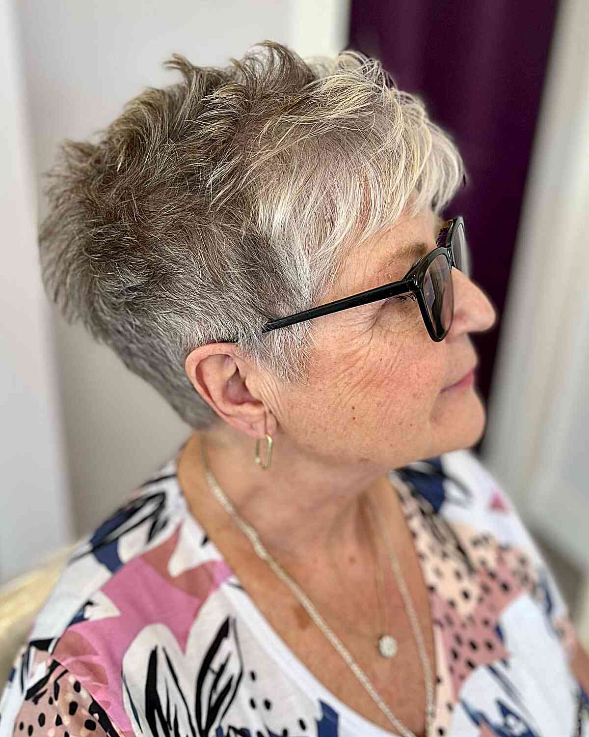 Um divertido corte pixie com cor natural para mulheres com mais de 60 anos e cabelos finos.