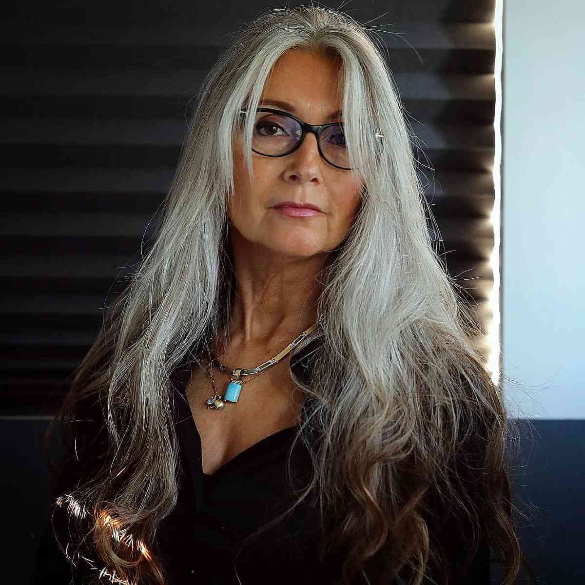 Penteado prateado longo para mulheres com mais de 50 anos com óculos