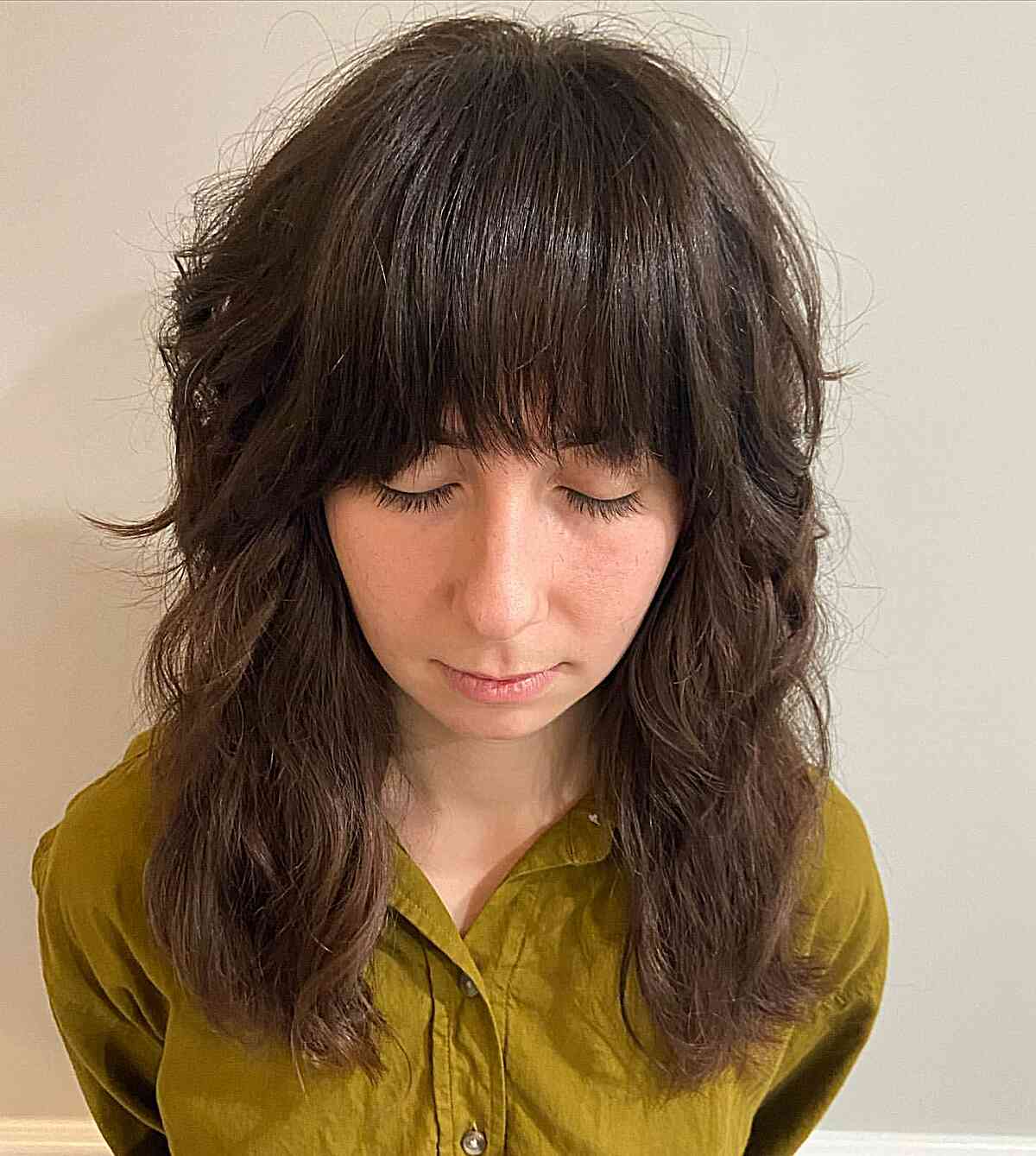 Um corte de cabelo para morenas de comprimento médio com um estrondo reto e estilos curtos para cabelos grossos