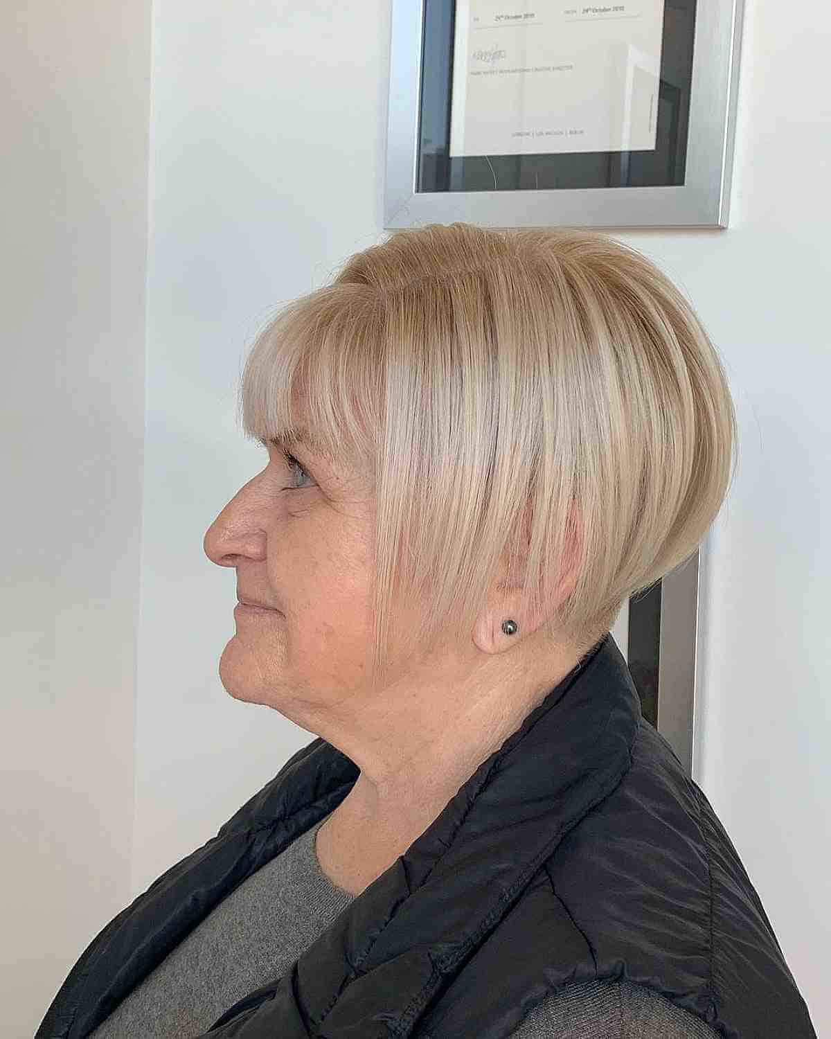 Feijão curto com franja e corte de cabelo sob um quadrado para mulheres mais velhas