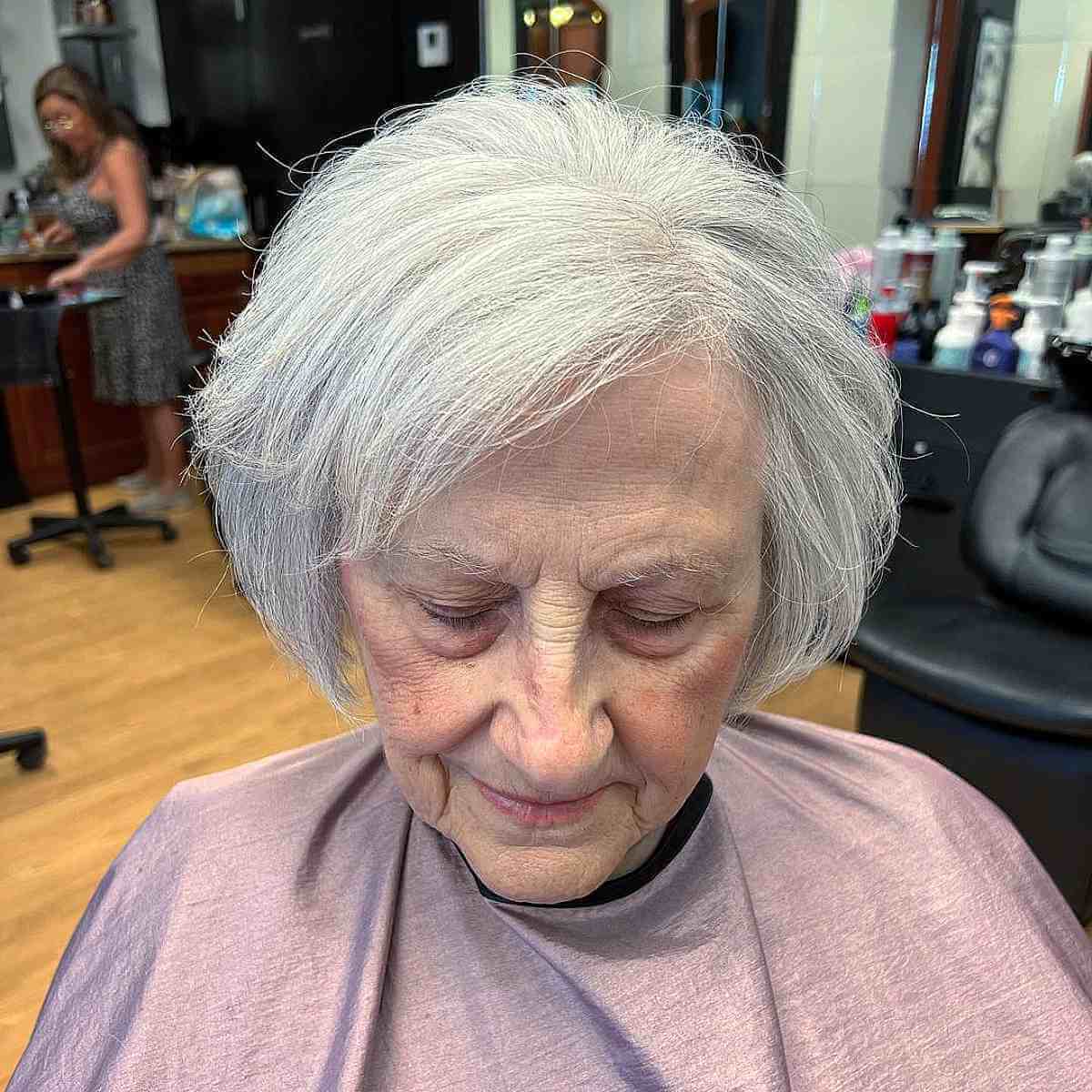 Bob empilhado com franja lateral para cabelos brancos em mulheres mais velhas